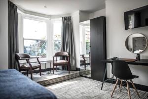 a living room with a mirror and a table and chairs at Sinclair's Rooms in Southport