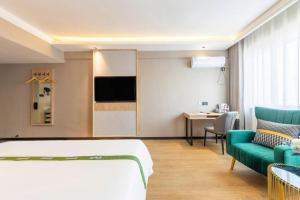 une chambre d'hôtel avec un lit et un canapé dans l'établissement GreenTree Inn Express Dongying Lijin County Ginza Market, à Dongying