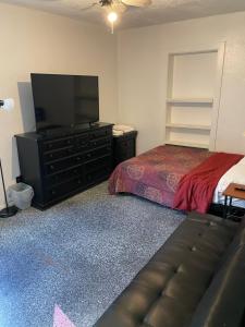 フェニックスにあるPhoenix Hollywood Private Roomのベッドと薄型テレビのある寝室