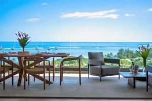 a dining room with a table and chairs and the ocean at Domaine d'Anbalaba - Baie du Cap - Ile Maurice in Baie du Cap +65 photos