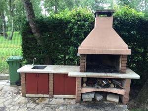 a outdoor oven with a sink in a yard at Aqua Family Apartments in Karigador