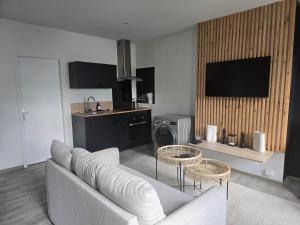 a living room with a couch and two tables at Idéal couples & pro - Patio extérieur- Proche centre ville et gare - Promenade au bord de la Charente - Parking à proximité - Wifi très haut debit - Équipement premium -Netflix in Angoulême