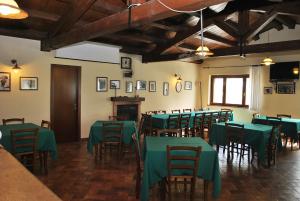 una sala da pranzo con tavoli e sedie verdi di Agriturismo Oasi Belvedere a Monte San Pietrangeli