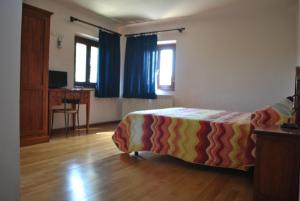 Monte San PietrangeliにあるAgriturismo Oasi Belvedereのベッドルーム1室(ベッド1台、デスク付)