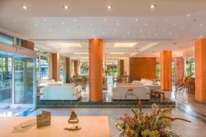 a lobby of a hotel with tables and chairs at Pavlos Hotel in Kos Town