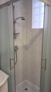 a shower with a glass door in a bathroom at Baltic coast Apartments in Liepāja