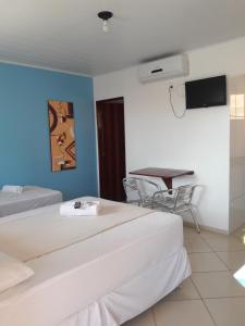 Habitación de hotel con 2 camas y mesa en Viking Flat, en Praia do Frances