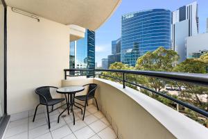 a balcony with a table and chairs and a view of the city at 1 Valentine Ave in Sydney