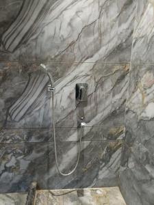 a shower in a bathroom with a marble wall at Taj Castle by iO Hotels in Amritsar