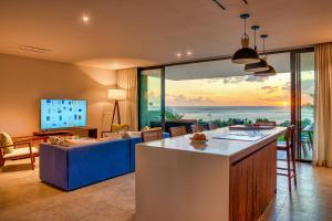 a kitchen and living room with a view of the ocean at Domaine d'Anbalaba in Ruisseau Créole