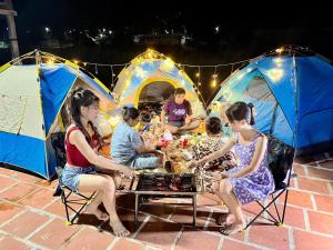 a group of people sitting around a table in tents at Chamka Sne LyLy Resort in Phumĭ Stœ̆ng Chral
