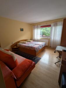 a bedroom with two beds and a couch and a window at Vila lui Simion in Rimetea