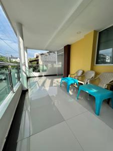 Un balcón con sillas y mesas en un edificio. en Hotel Gixael, en Santa Marta