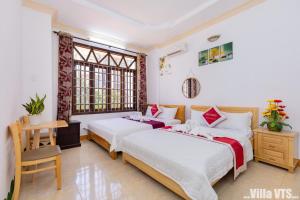 1 Schlafzimmer mit 2 Betten, einem Schreibtisch und Fenstern in der Unterkunft Biệt Thự Hồ Bơi VTU Bãi Sau in Vũng Tàu + 31 Fotos