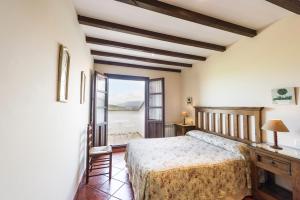 a bedroom with a large bed and a window at Apartamentos Rurales Antanielles in Ribadesella
