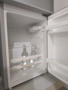 una nevera abierta con dos botellas de vidrio. en Superior Family Room, en Pantai Cenang