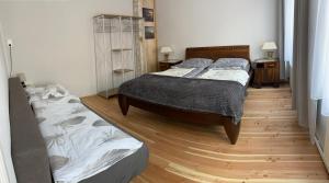 a bedroom with two beds and a wooden floor at Wohnung - Fisch Am kleinen Königsstuhl in Sagard +9 photos