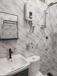 Un baño con un inodoro blanco y un lavabo. en Superior Family Room, en Pantai Cenang 31 fotos más