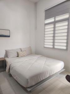 Una cama en una habitación blanca con ventana. en Superior Family Room, en Pantai Cenang