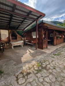 a wooden pavilion with a bench and a table at Vila lui Simion in Rimetea