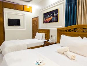 une chambre d'hôtel avec deux lits et une télévision dans l'établissement Hotel StayInn, à Karachi 19 autres photos