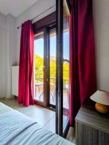 a bedroom with a bed and a window with red curtains at Olympus House με μοναδική θέα in Litochoro