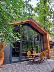 Un patio con una mesa y sillas frente a un edificio. en Naturcamping Brettmühlenteich, en Zschorna