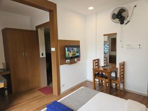 a bedroom with a bed and a table and a tv at SUROOR Recidency in Virajpet
