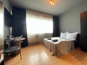 una camera da letto con un letto, un tavolo e una finestra di M-Studios in Stuttgart Zentrum a Stoccarda