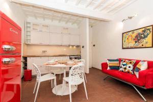Una sala de estar con una mesa y un sofá rojo. en Pinocchio House, en Florencia