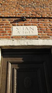 een bord boven de deur van een bakstenen gebouw bij Hotel Guesthouse Begijnhof in Leuven