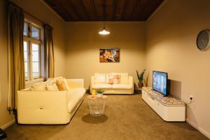 a living room with two white couches and a television at Villa Newstead Luxury Stay Near Hamilton in Newstead +42 photos