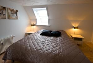 1 dormitorio con 1 cama con 2 almohadas en Den Gamle Købmandsgaard Bed & Breakfast en Ribe