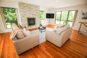 a living room with two couches and a fireplace at Alpine Nest in Bright