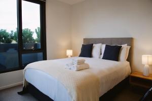 a bedroom with a bed with two towels on it at Signature Suite - 2BR 2Bath Stay in Melbourne