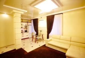 ein Wohnzimmer mit einem weißen Sofa und einem Tisch in der Unterkunft Ultra Central Park Apartments in Chişinău