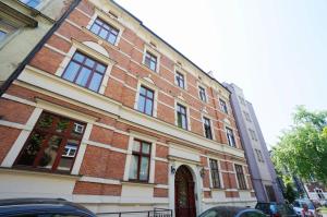 un edificio de ladrillo rojo con ventanas y una puerta en Apartment Zegadłowicza en Cracovia