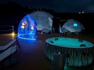 蓬扎Palmaria Sky Bubbles Room的晚上的冰屋和热水浴缸