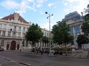 ein großes Gebäude mit davor geparkt in der Unterkunft Le Paradis - Vieux Port, Studio avec climatisation in Marseille