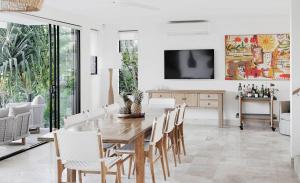 Un comedor con mesa y sillas de madera. en Elanda on Sunshine - Ocean views, see the whales, en Sunshine Beach