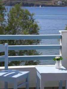 a white bench and a table with a view of the water at Hotel Paros in Parikia