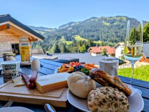 a plate of food on a table with a glass of wine at Alpenflair-Chalets-Balderschwang in Balderschwang