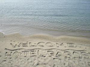 a sign written in the sand on the beach at Hotel Paros in Parikia