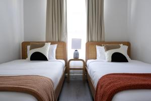 Dos camas una al lado de la otra en una habitación. en 104 EastPerth Euphoria Escape 2BR Parkng, en Perth