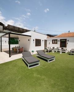 patio z dwoma łóżkami i trawnikiem w obiekcie V&C Luxury Village w mieście Breña Baja
