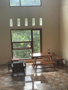a room with a wooden table and a large window at Purangjompa Homestay in Tiwuronto