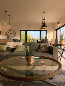a living room with a couch and a glass table at Spa & Pure Relaxation - Chalet Saint-Cerf in Saint Come