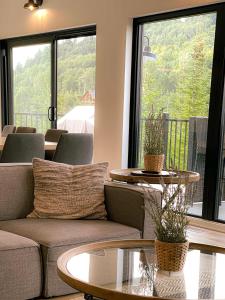 a living room with a couch and tables and a large window at Spa & Pure Relaxation - Chalet Saint-Cerf in Saint Come +47 photos