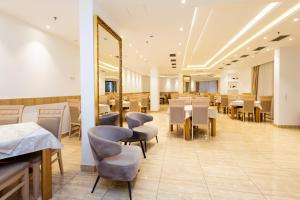 a restaurant with tables and chairs and a mirror at Hotel PIO in Ulcinj