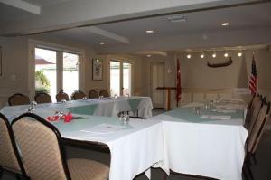 a dining room with white tables and chairs and a flag at Royal Copenhagen Inn in Solvang